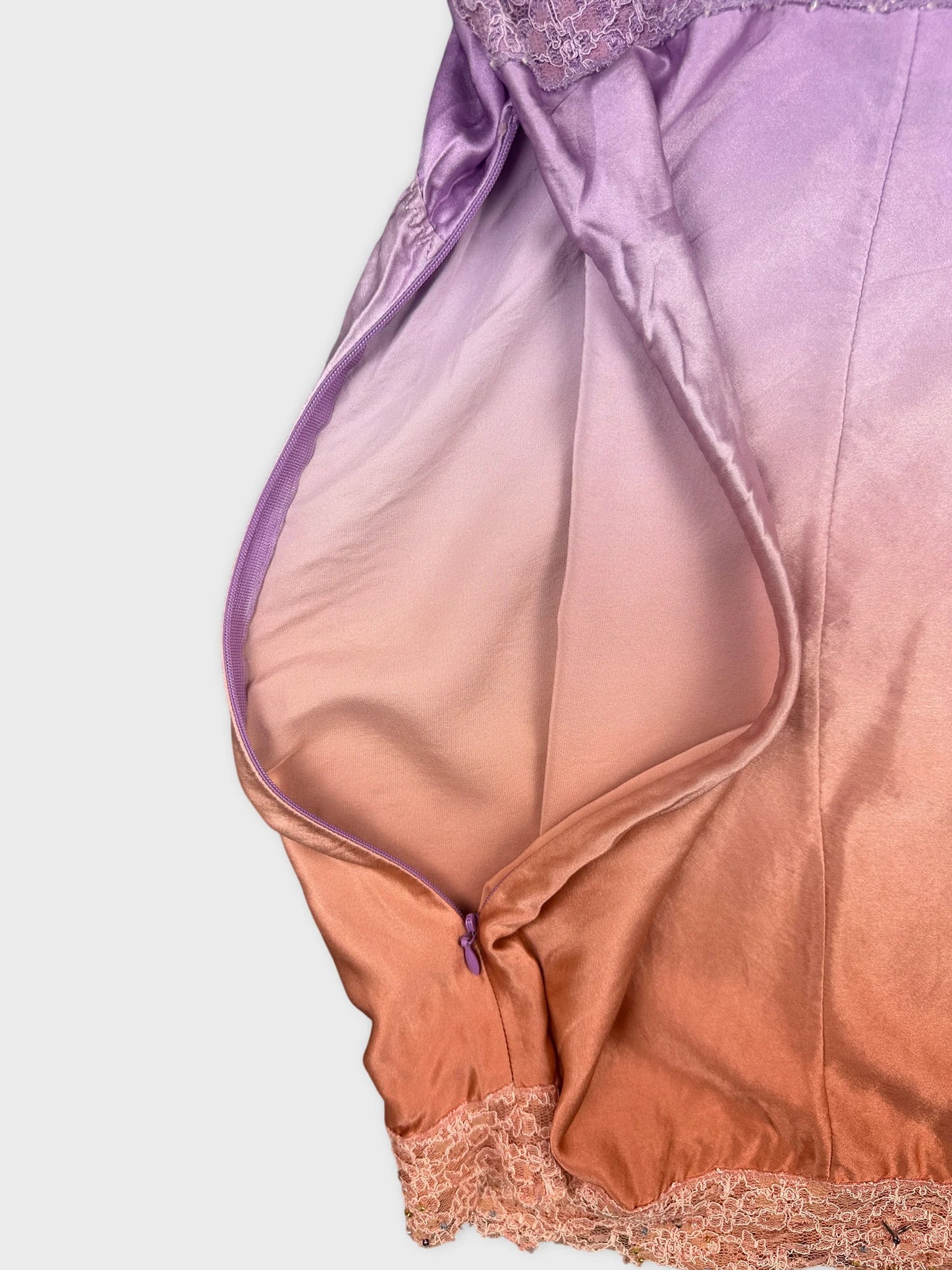 Detail view of a vintage women's top in lavender with lace trim.