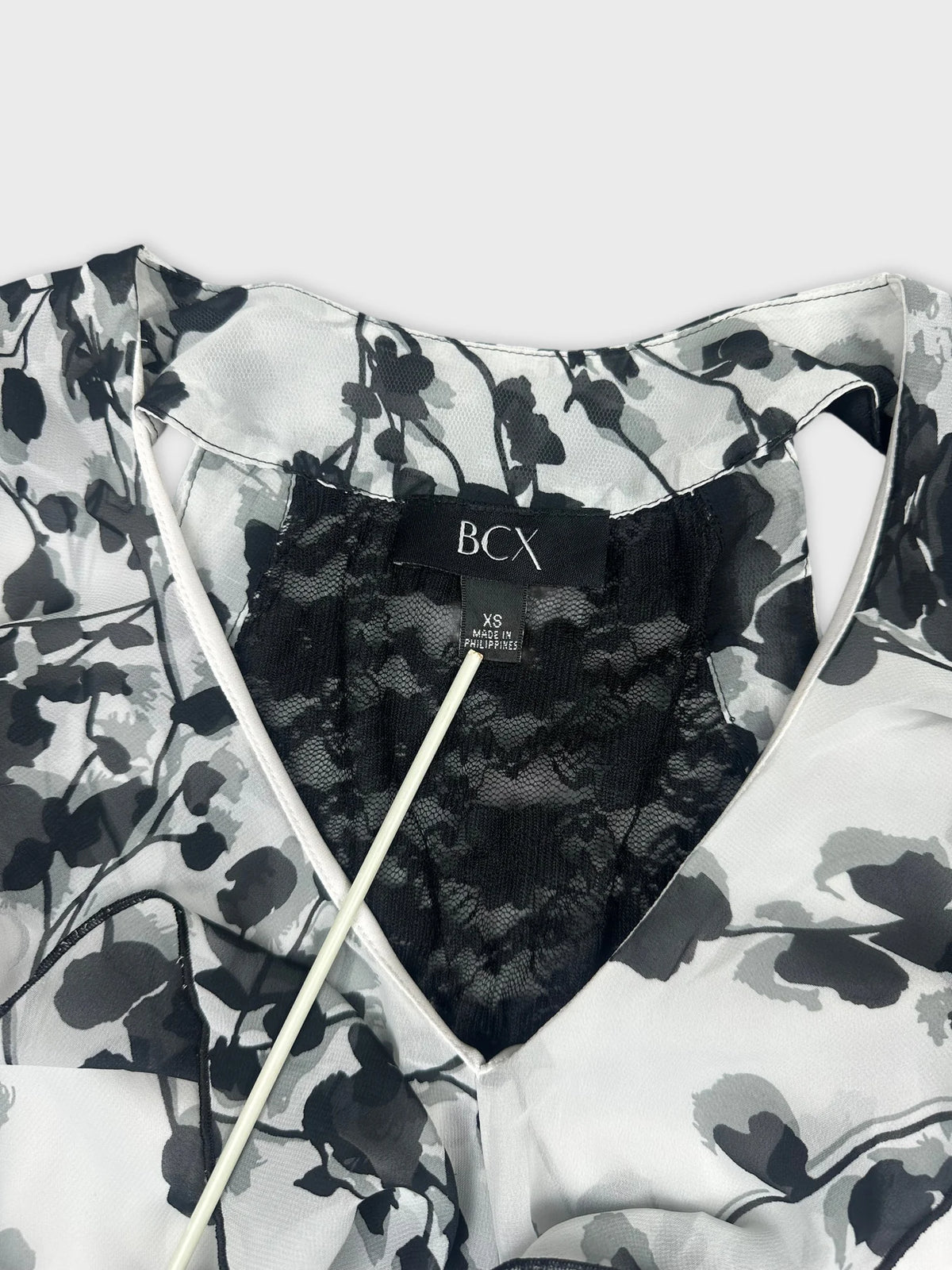 Detail view of a vintage black and white floral top with lace trim.
