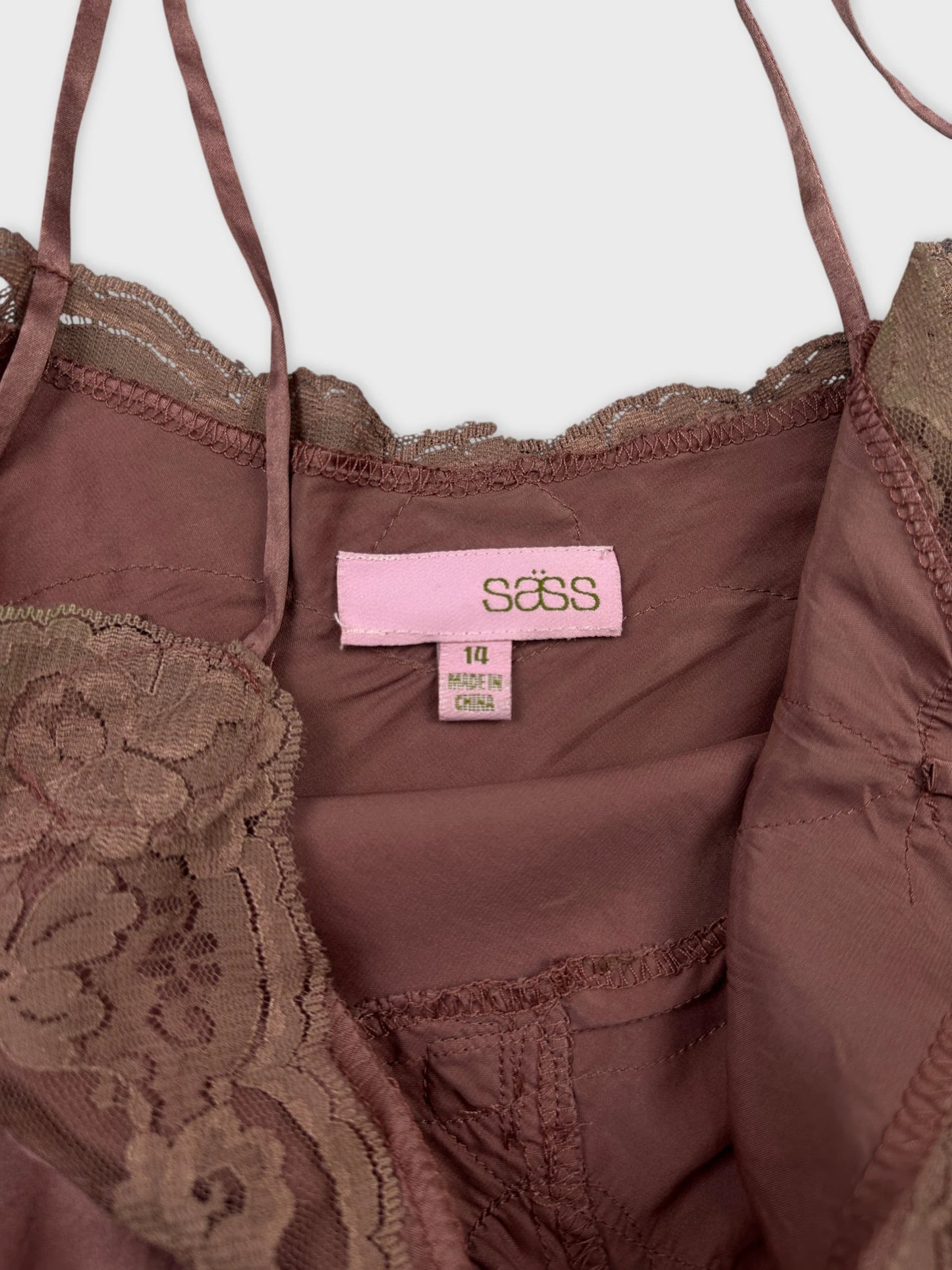 Detail view of a brown lace-trimmed women's top with adjustable straps.