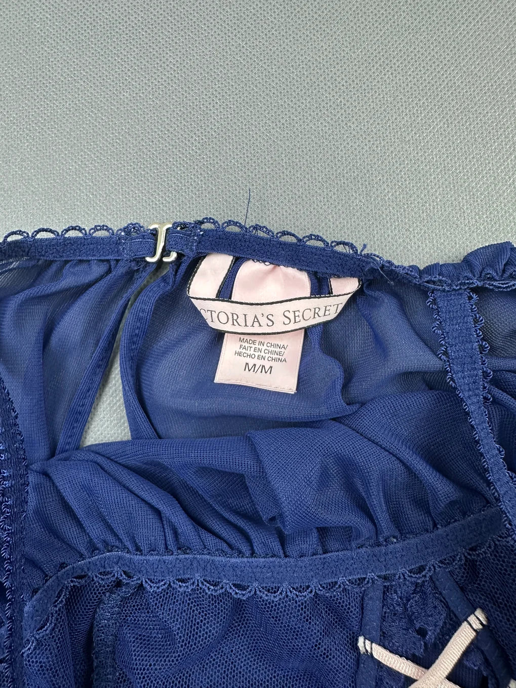 Detail view of a blue vintage upper body top with lace trim.
