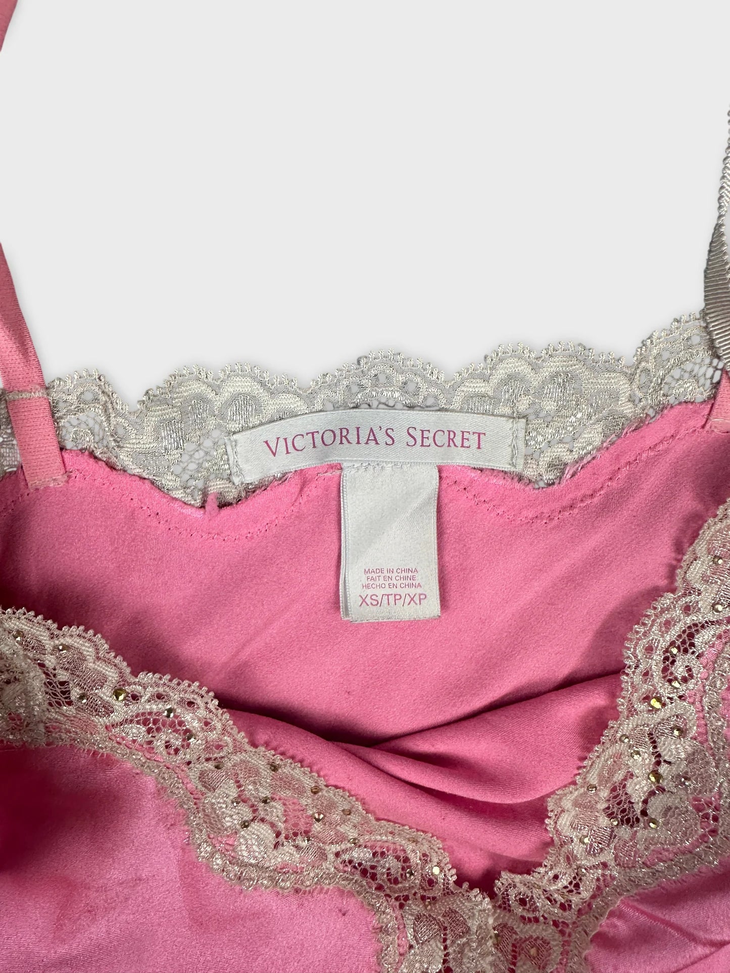 Detail view of a pink top featuring intricate lace trim.