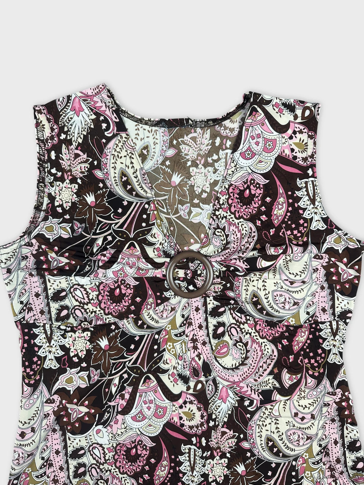 Detail view of a sleeveless top featuring a multicolor paisley pattern.