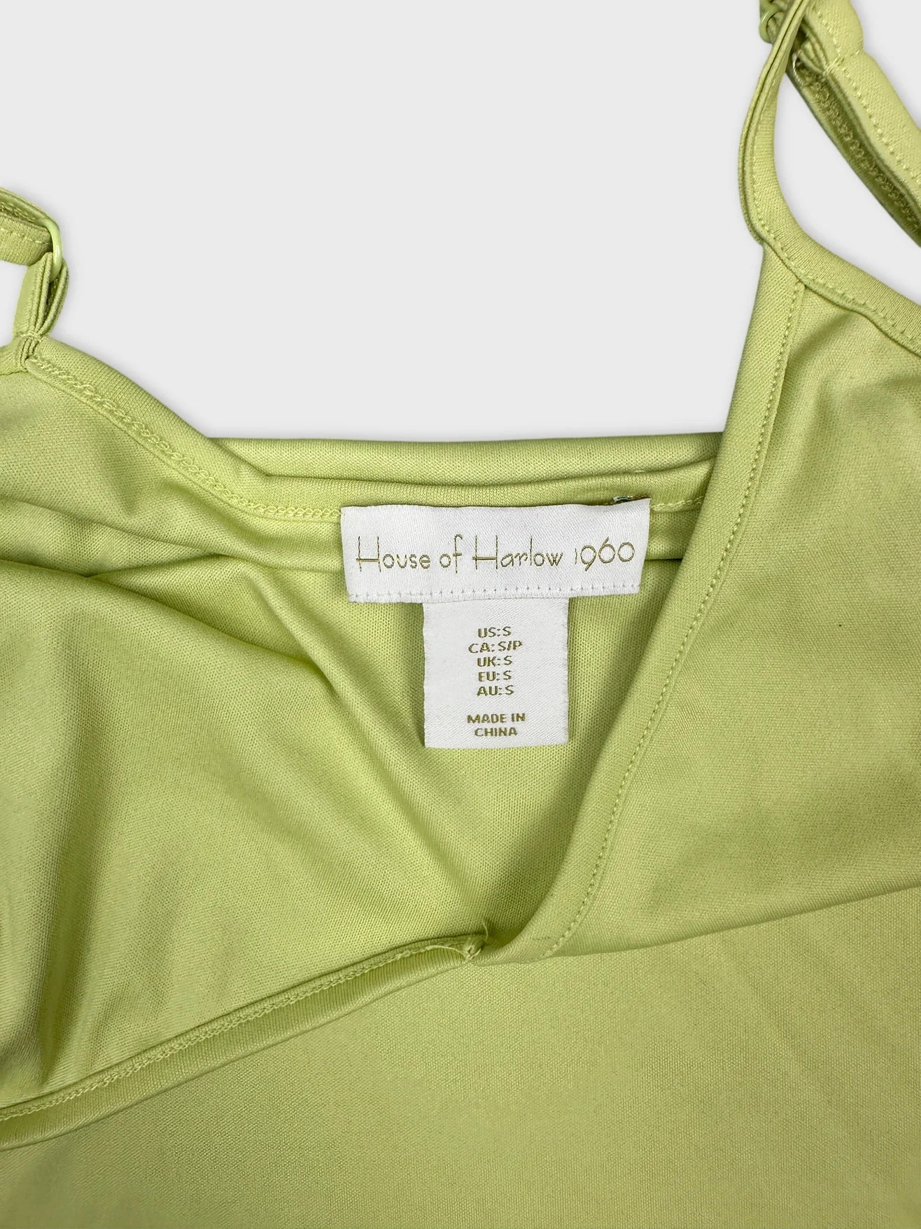 Detail view of a light green women's top with adjustable straps.