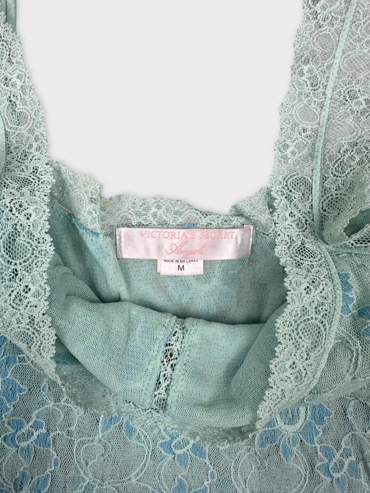 Detail view of a light blue lace top with intricate floral patterns.