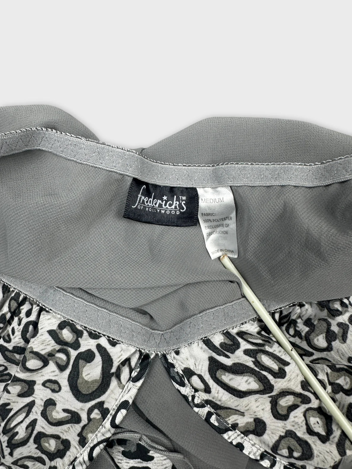 Detail view of a gray vintage top with leopard print trim.
