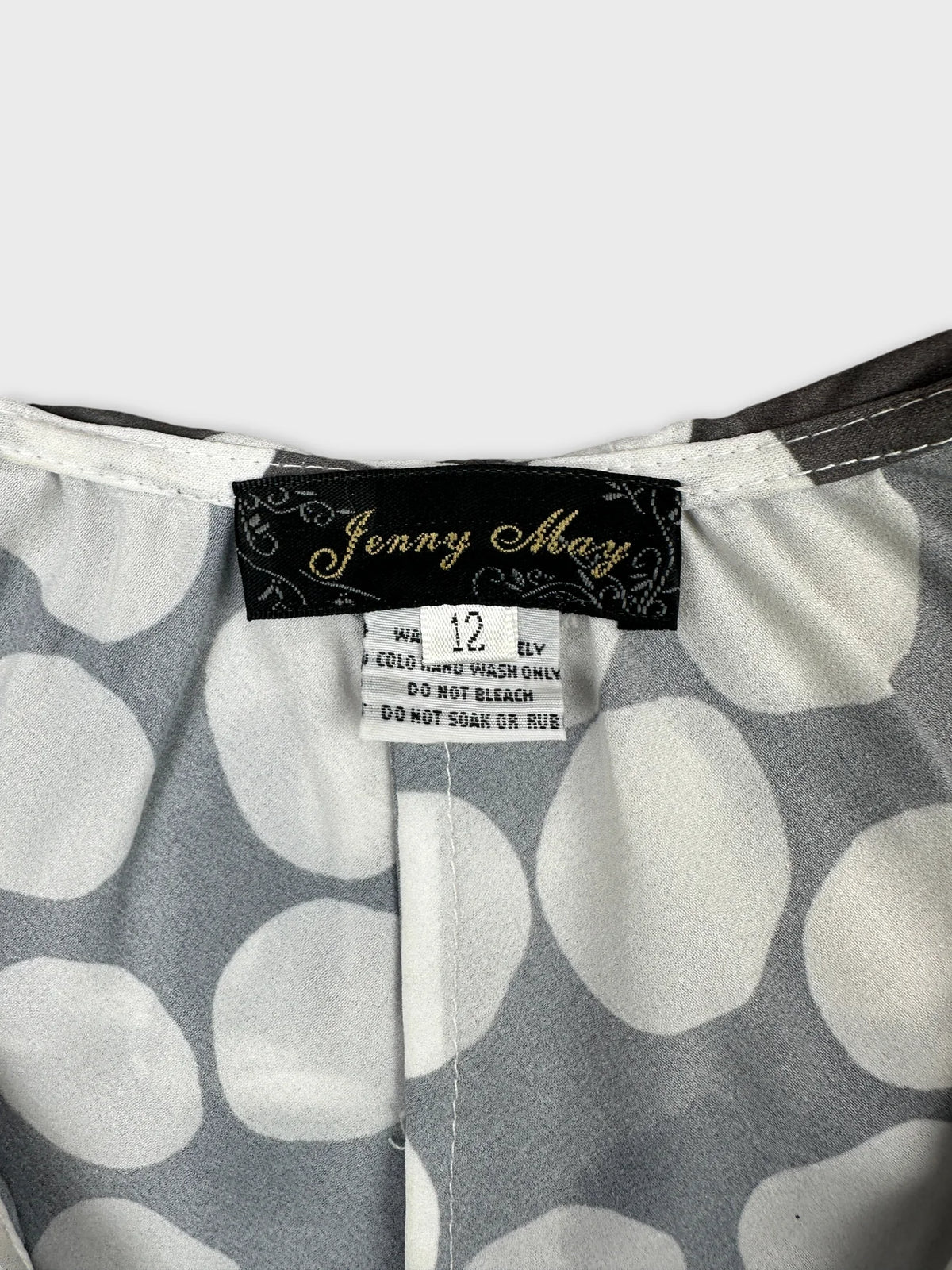 Detail view of a vintage gray top with white polka dots.