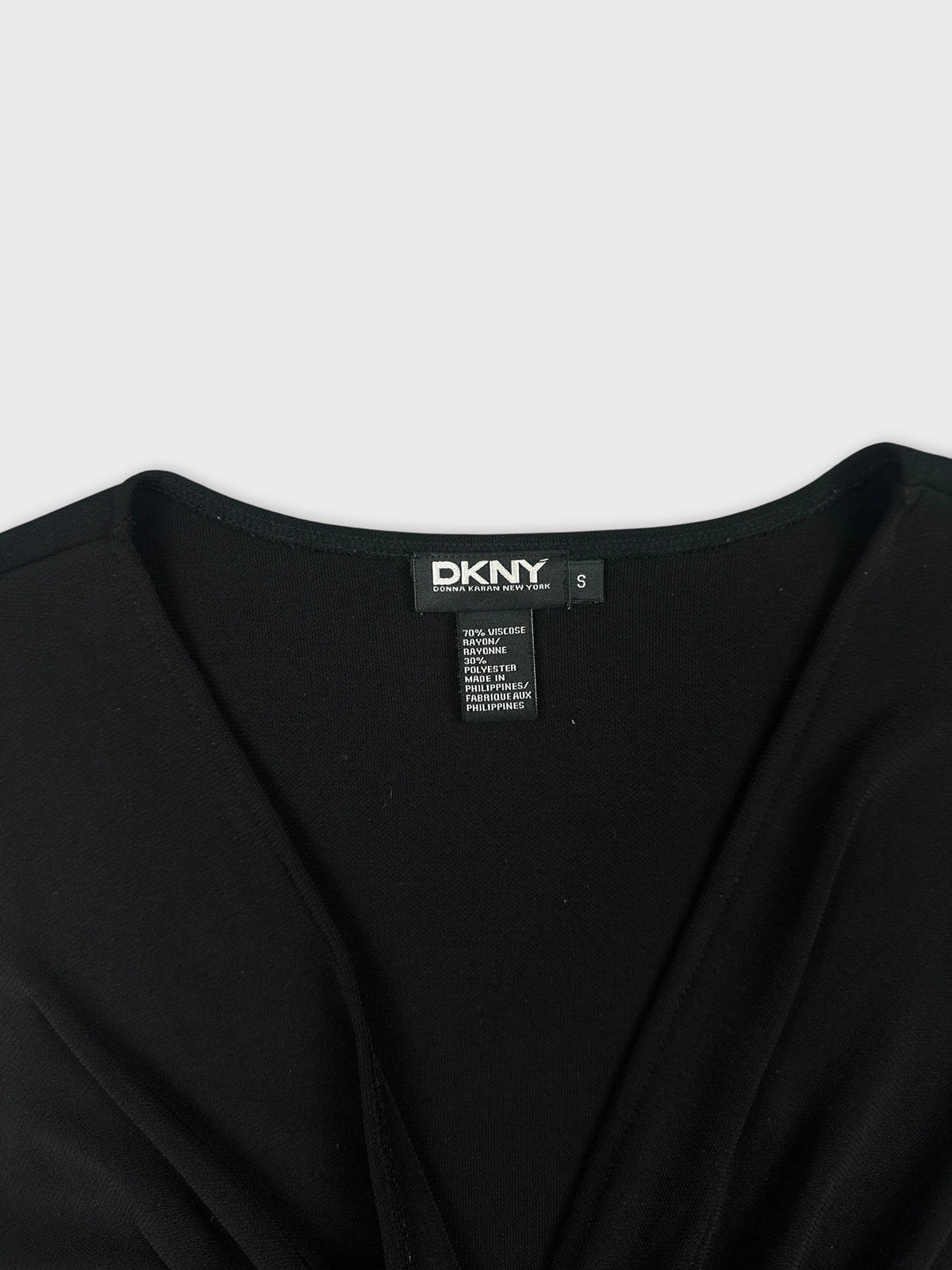 Detail view of a black women's top with a v-neck design.