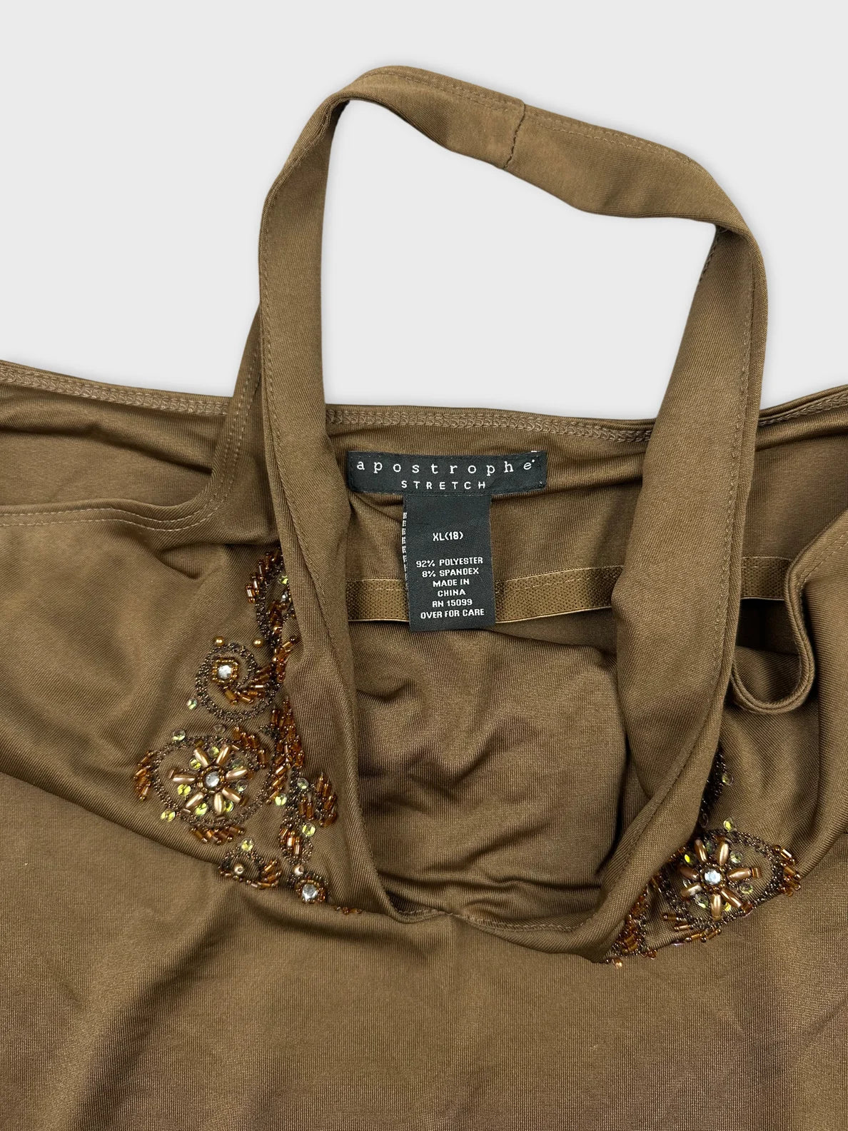 Detail view of a brown top featuring intricate beaded embroidery.