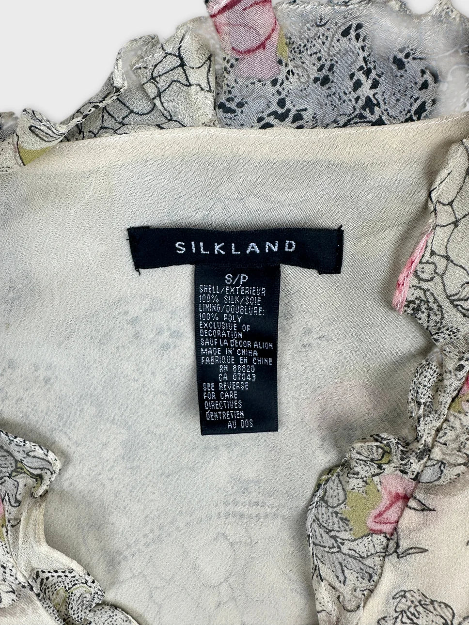 Detail view of a vintage top featuring a floral pattern in soft colors.