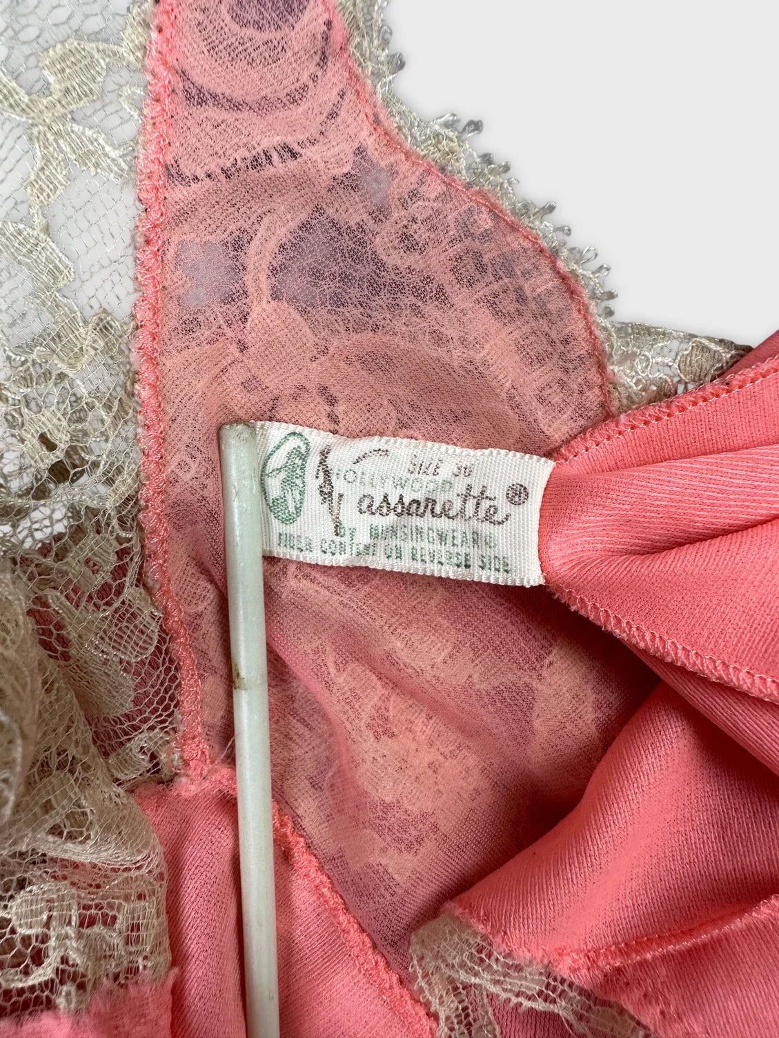 Detail view of a vintage pink top with lace trim.
