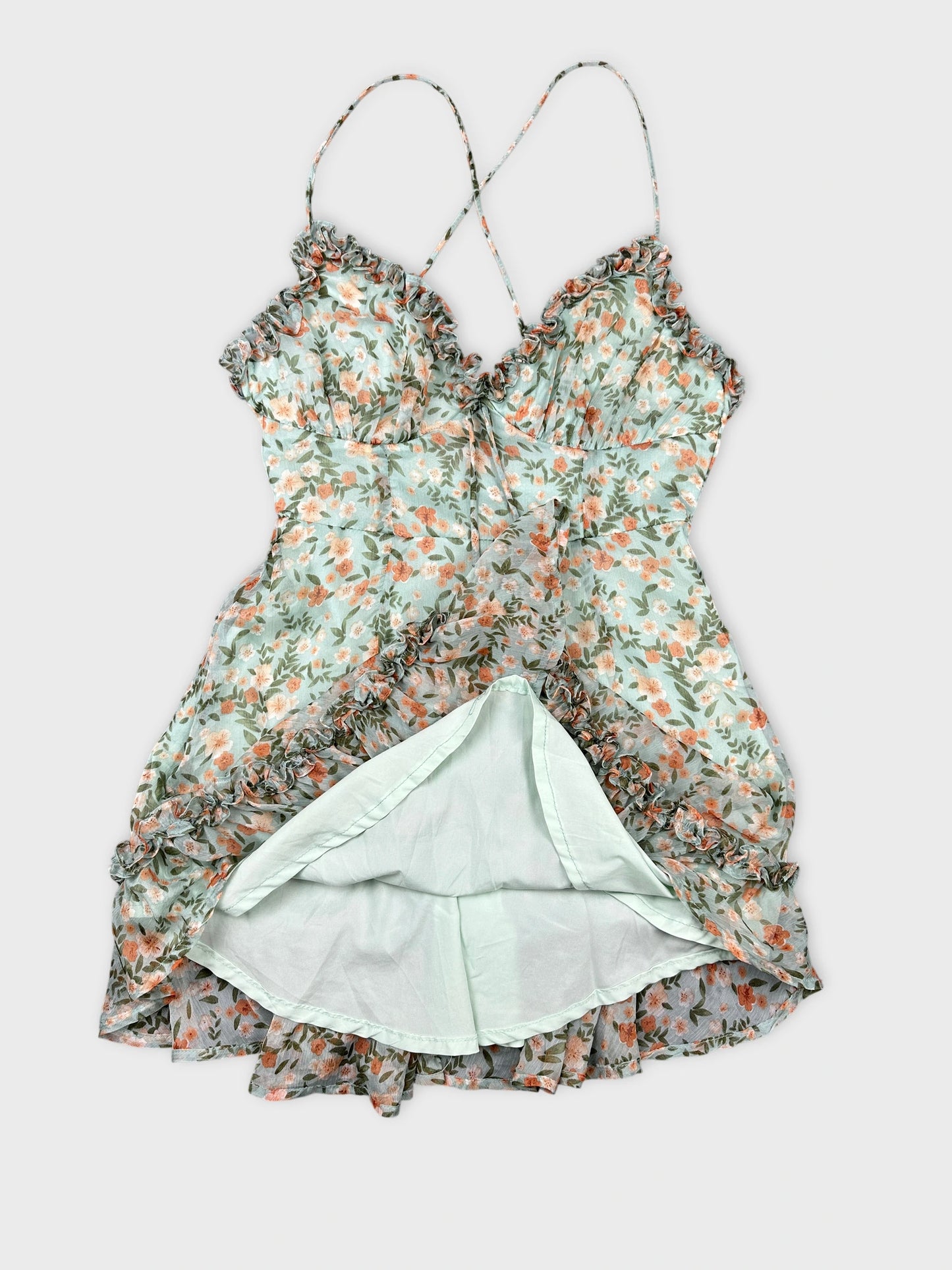 Detail view of a floral light blue women’s top with ruffled trim.