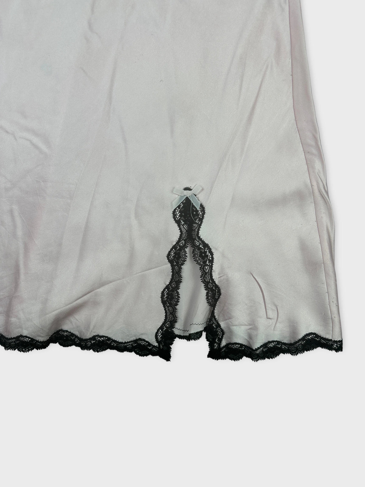 Silky pink upper body top with black lace detail view.