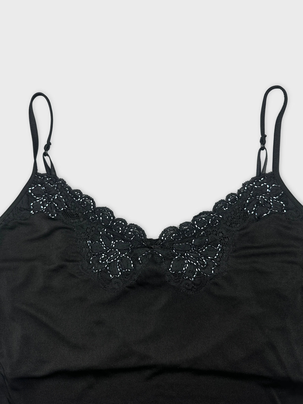 Detail view of a black camisole top with lace trim.