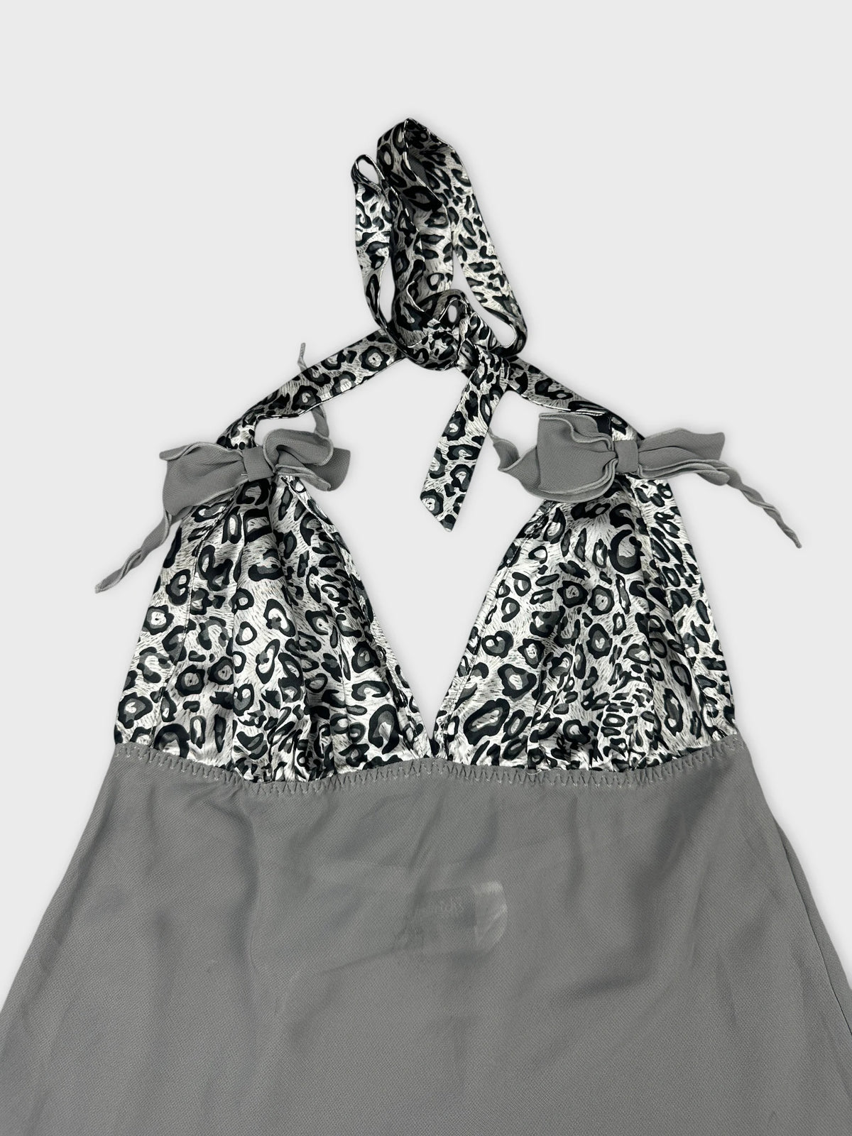 Detail view of a gray halter top with leopard print trim.