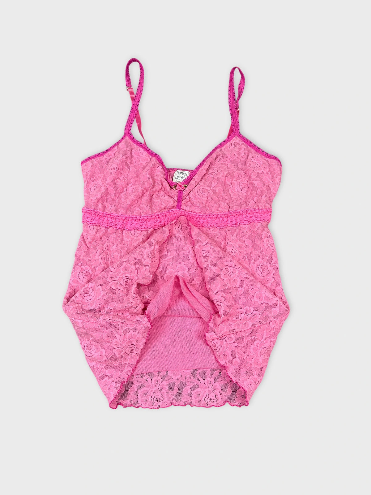 Detail view of a pink lace camisole with thin straps.