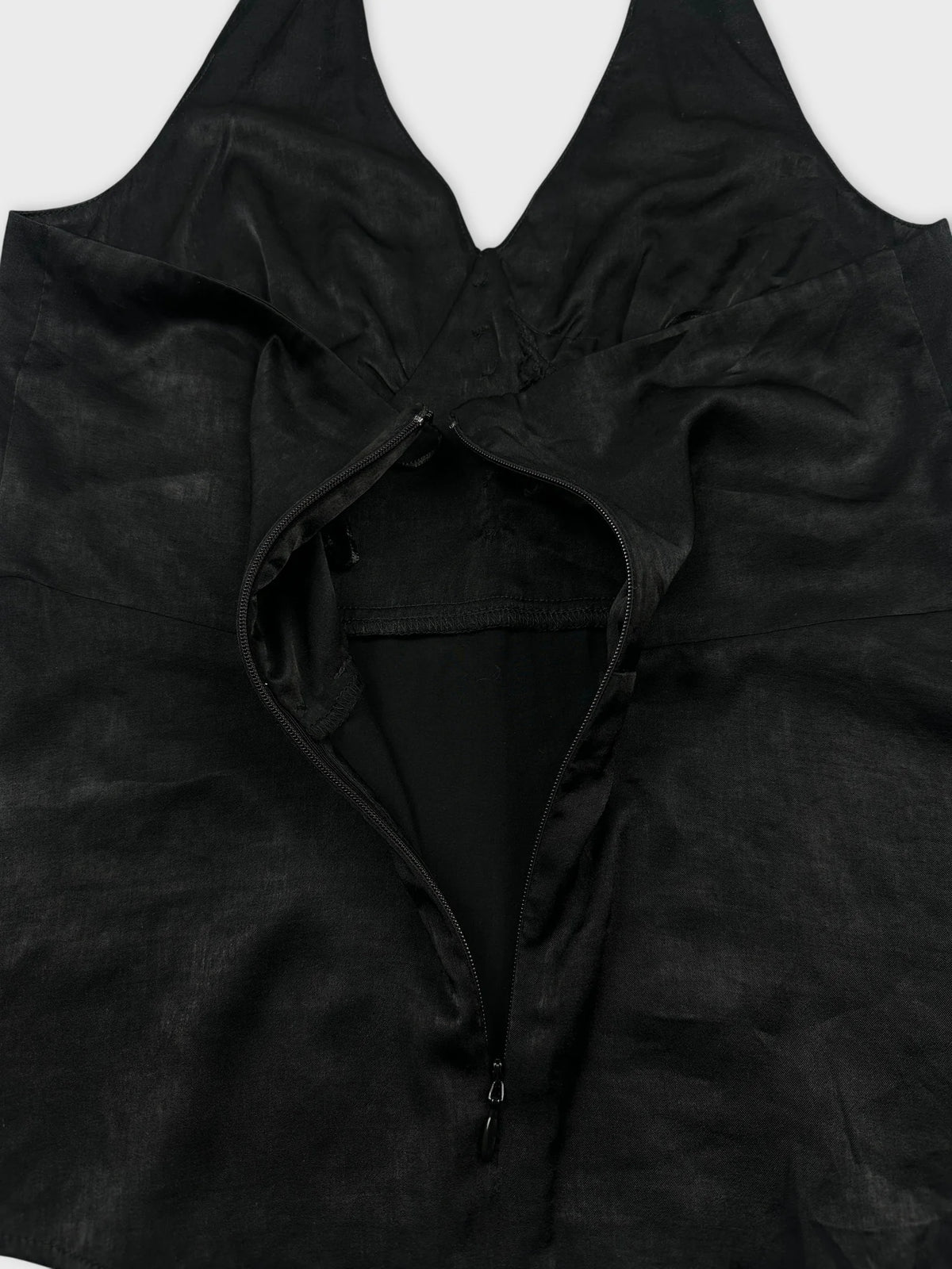 Black top detail view featuring a zip closure and halter neckline.