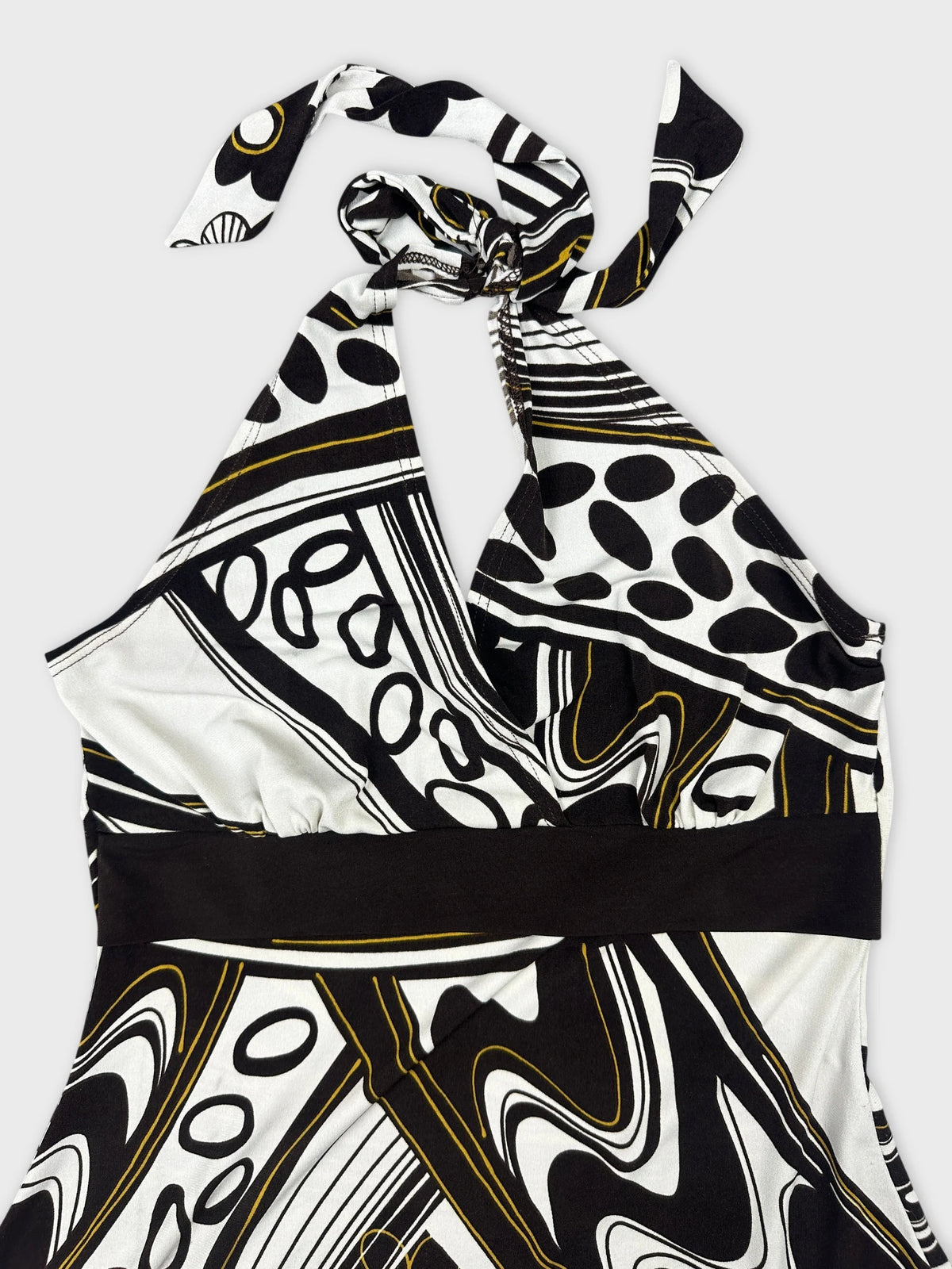 Detail view of a black and white patterned halter-top with a tied neckline