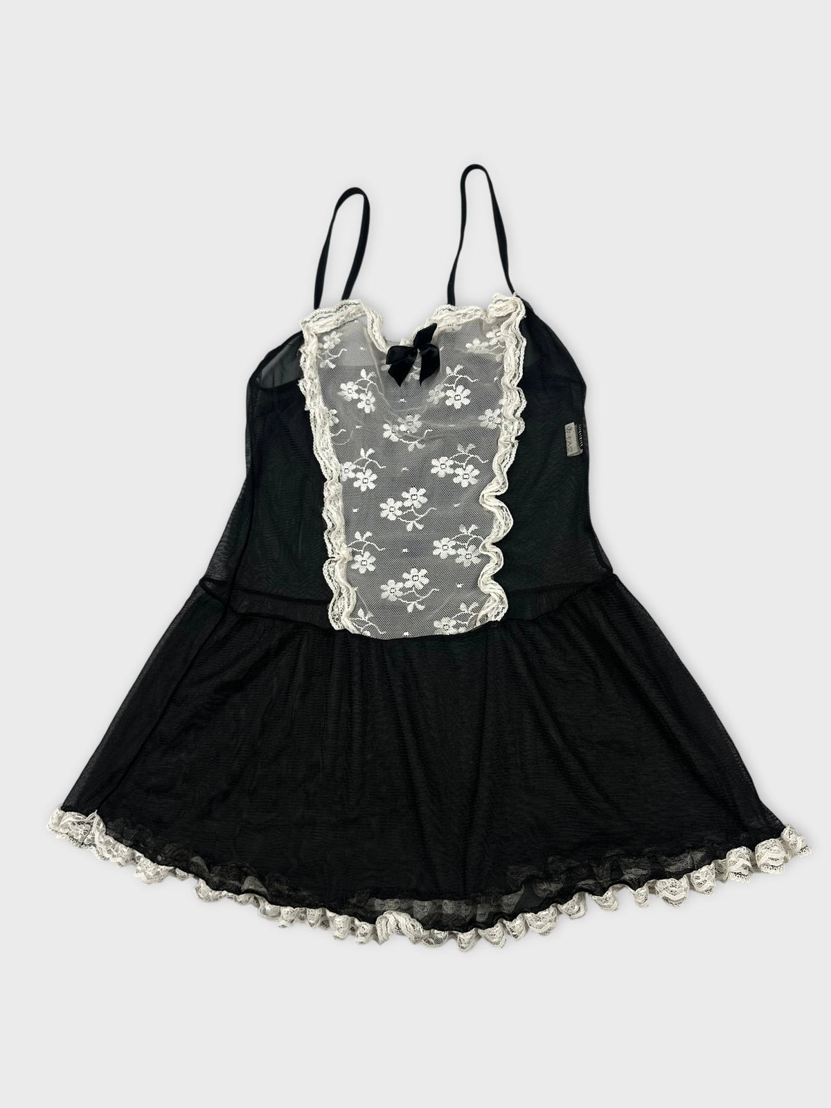 Detail view of a black vintage top featuring lace trim and floral mesh.