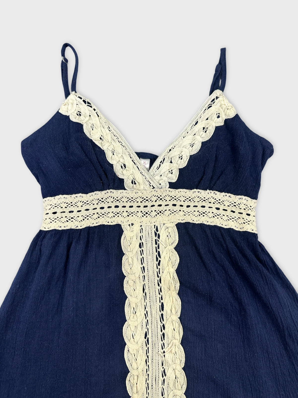 Detail view of navy upper body top with lace trim.
