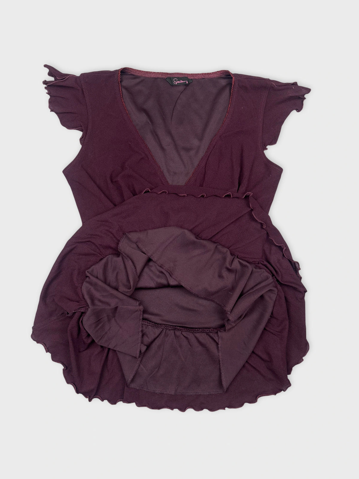 Detail view of a burgundy women's top with ruffled sleeves.