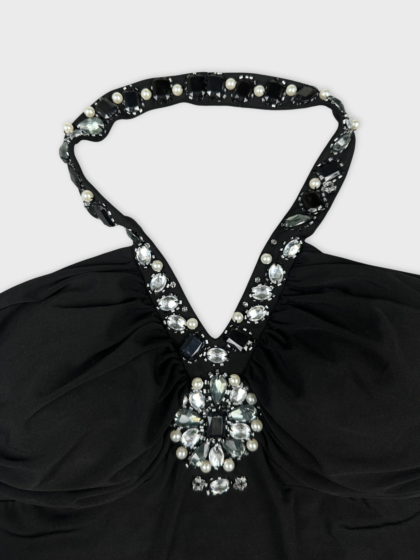 Detail view of black vintage top with jeweled neckline embellishment.
