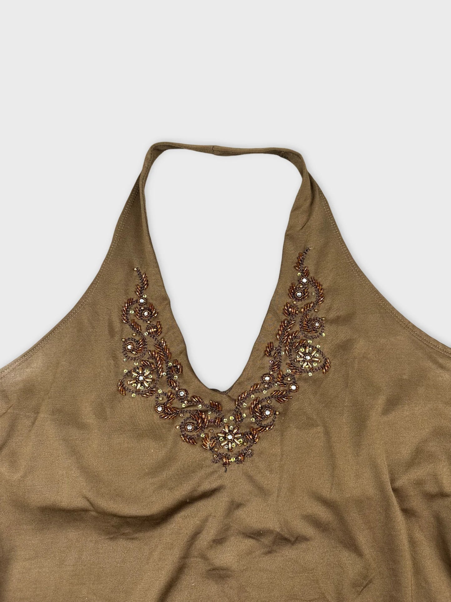 Detail view of a brown halter top with embellished neckline