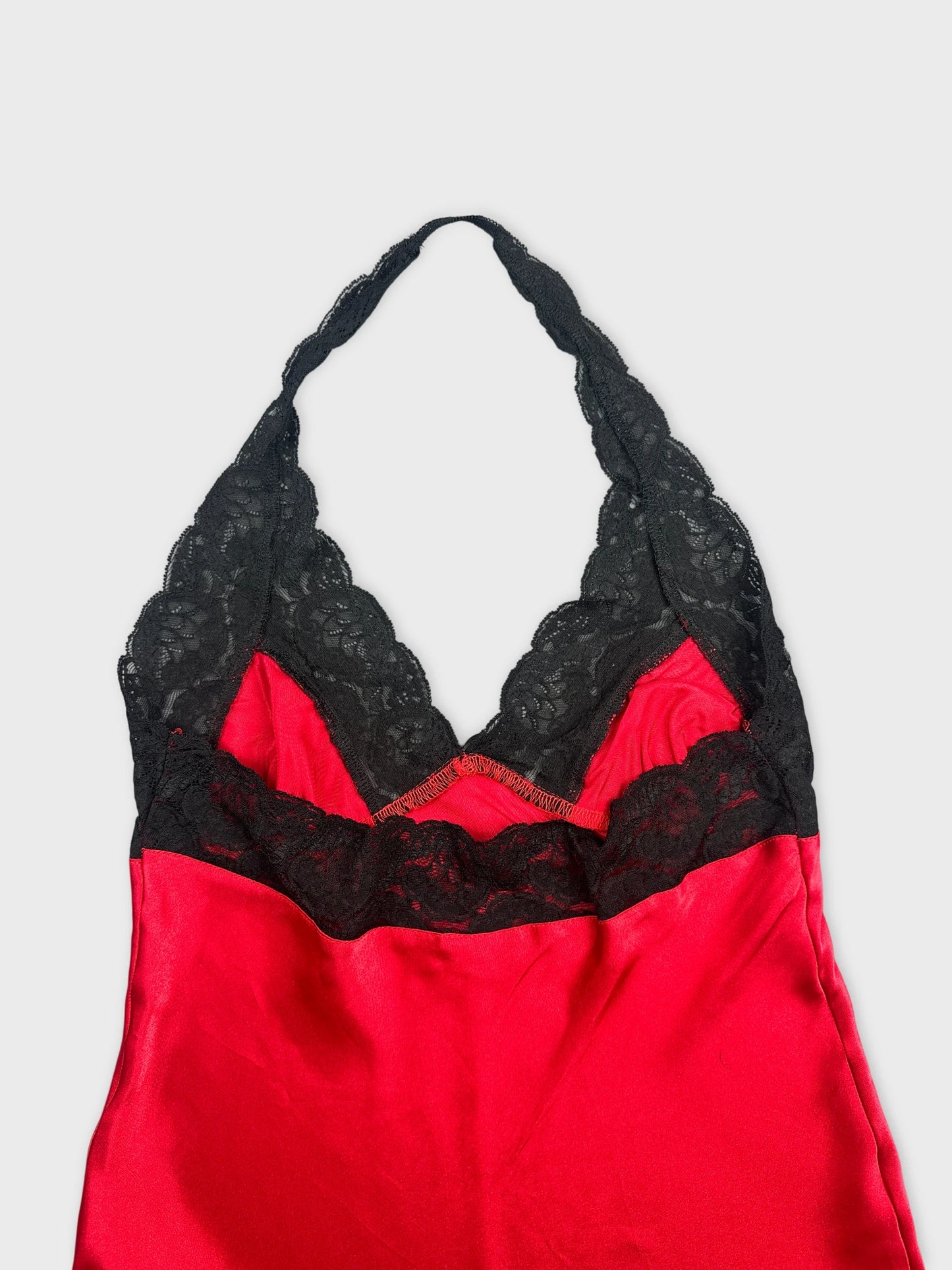 Detail view of a red silk top with black lace trim