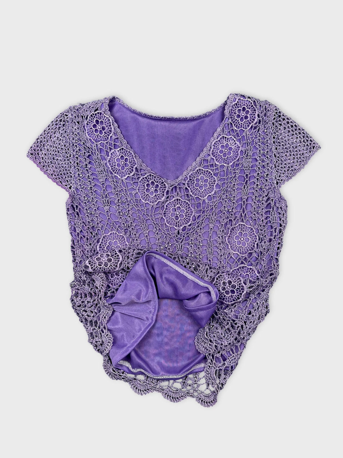 Detail view of purple crochet top featuring floral patterns.
