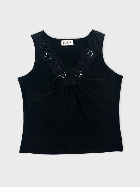 Front view of a black women's top with lace trim and embellishments.