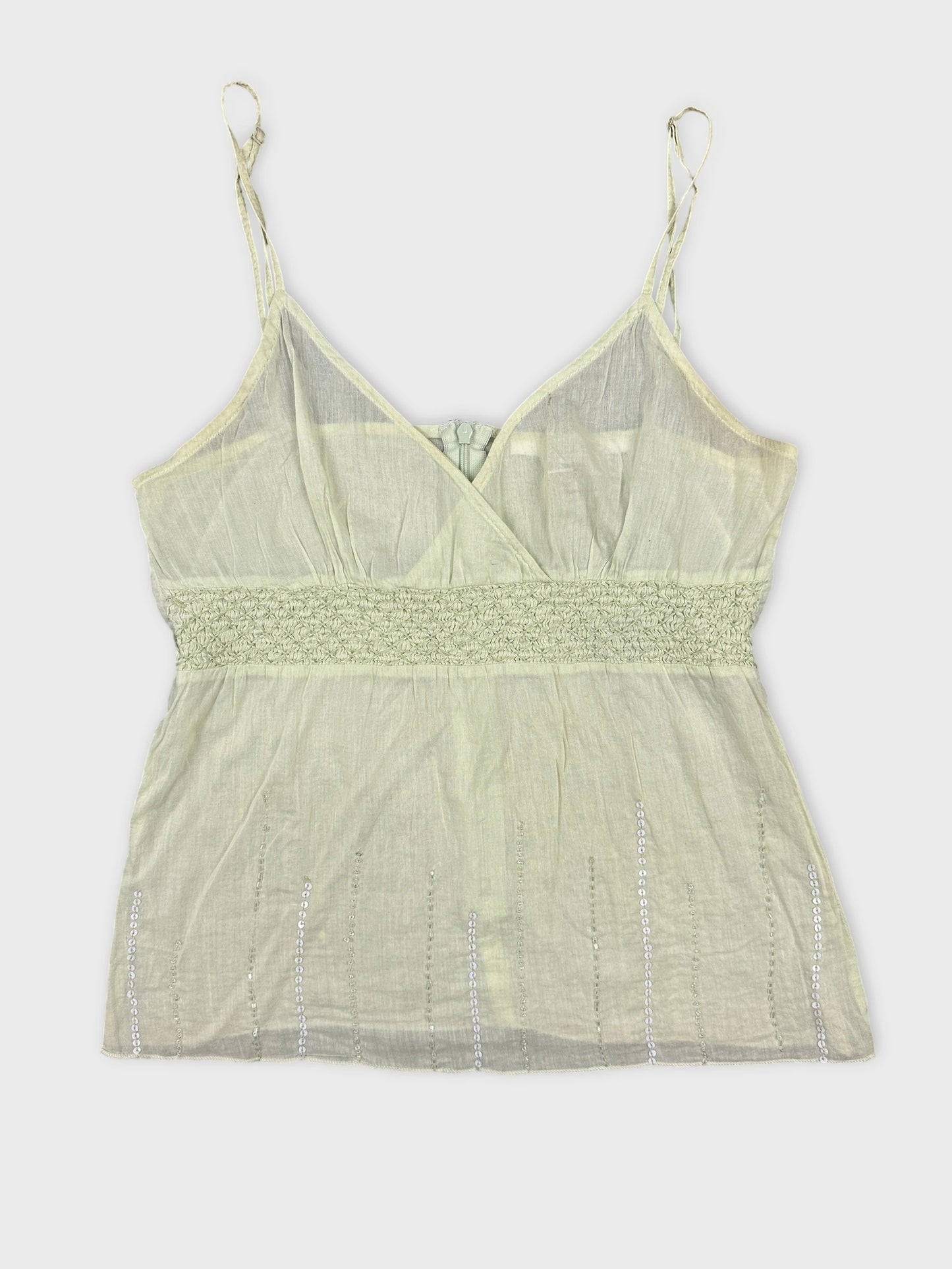 Front view of a light green tank top with smocked waistband and beaded details.