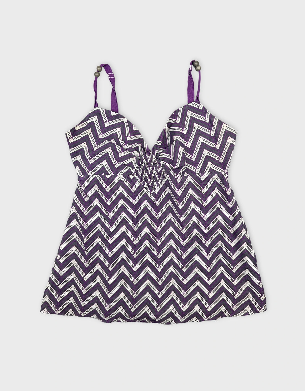 Front view of a purple chevron patterned women's top with adjustable straps.