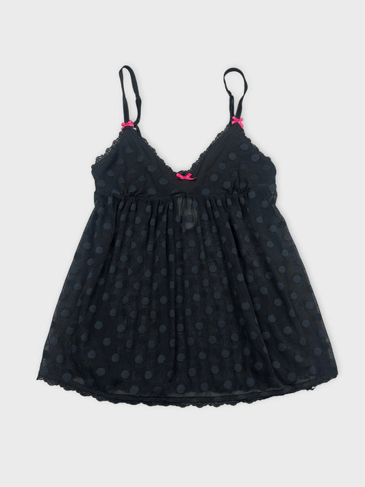 Front view of a black polka dot tank top with pink bows.