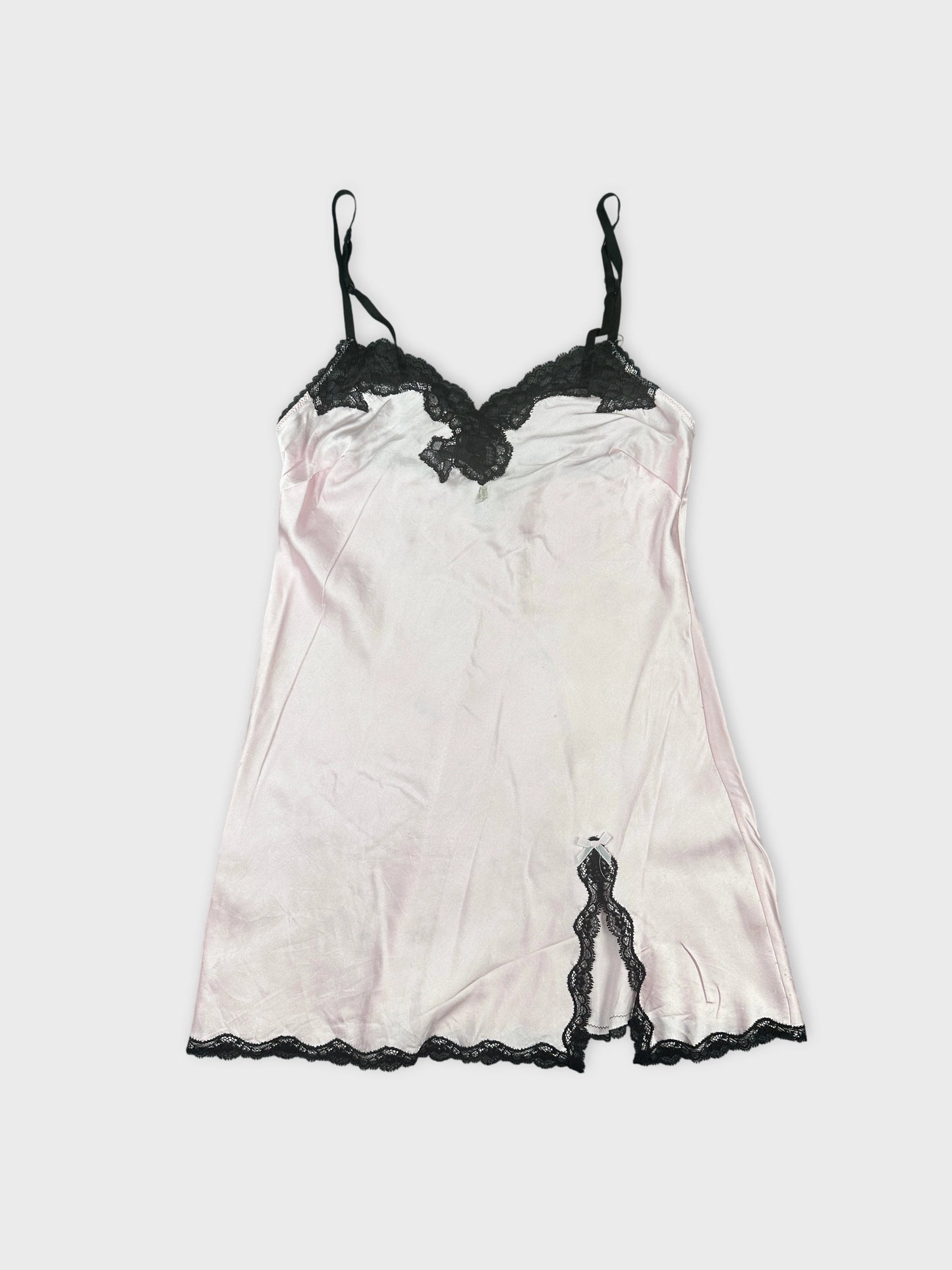 Front view of a pink vintage slip top with black lace trim.