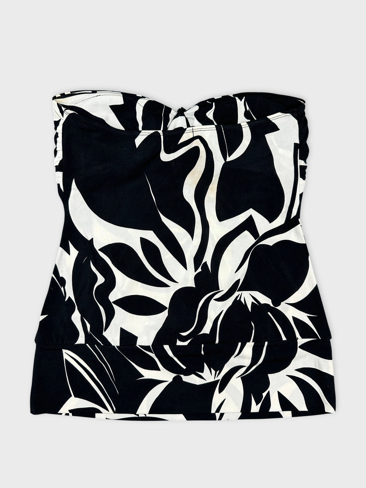 Front view of a black and white floral top with a fitted design.