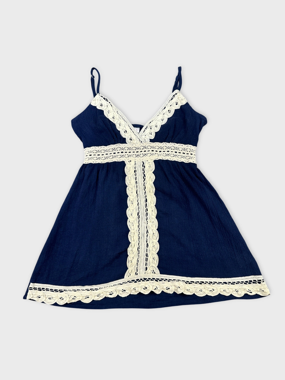 Front view of a navy blue sleeveless top with white lace trim.