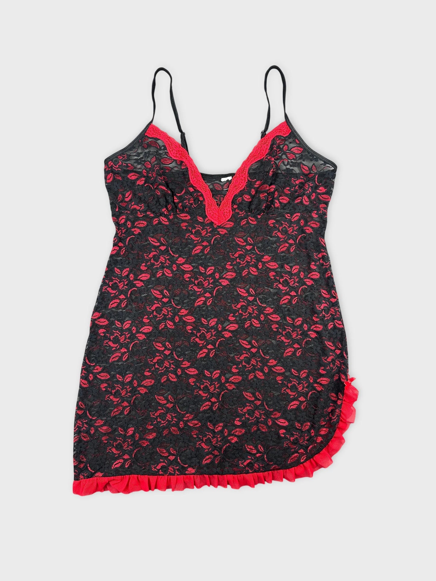 Black vintage top with red floral pattern and ruffled hem, front view.