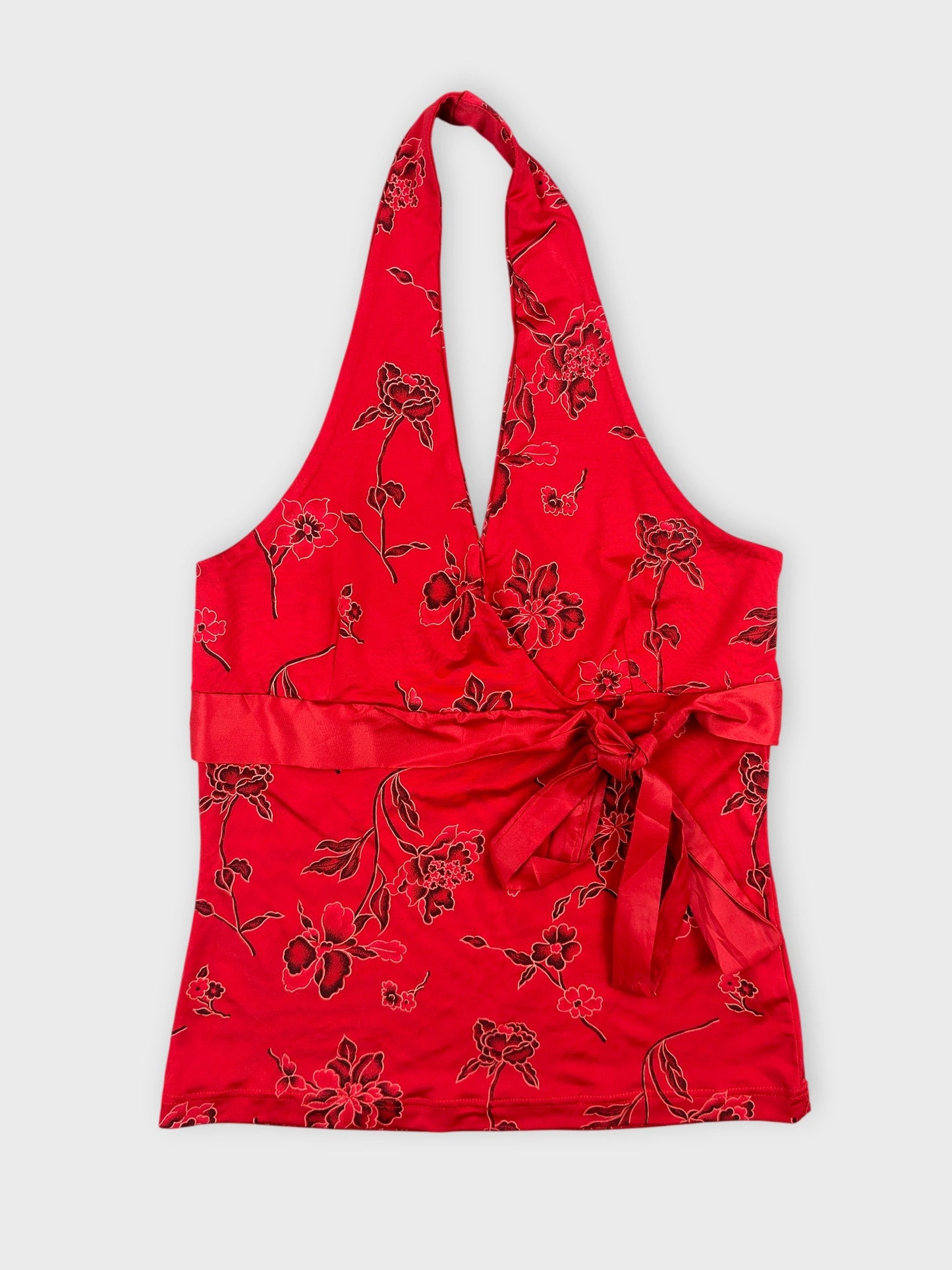 Front view of a red floral halter top with a tied waist.