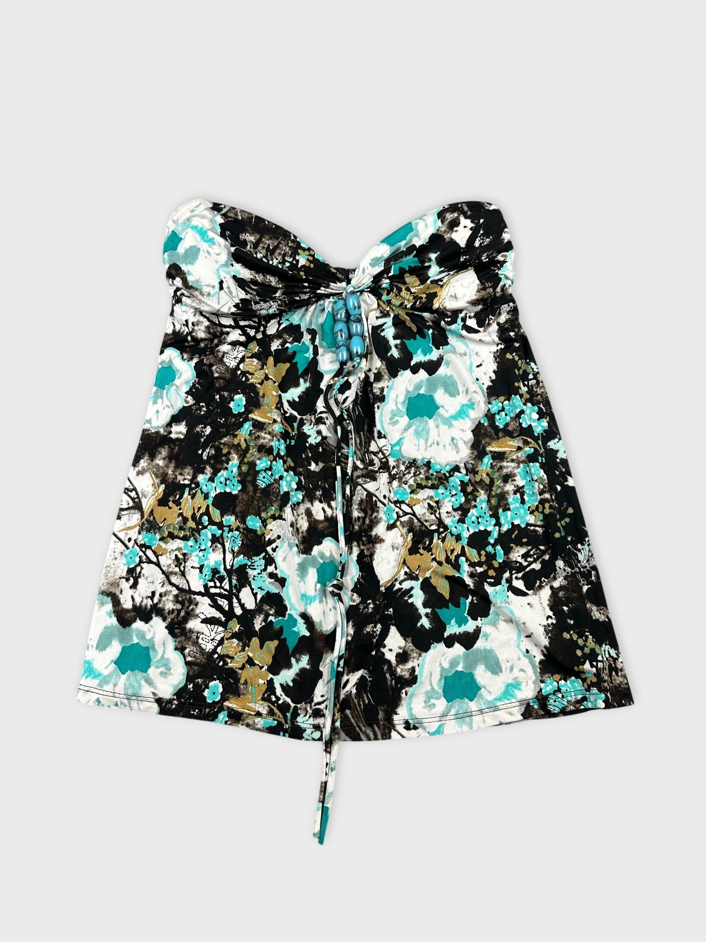 Front view of a strapless floral top in black and teal with a drawstring detail.