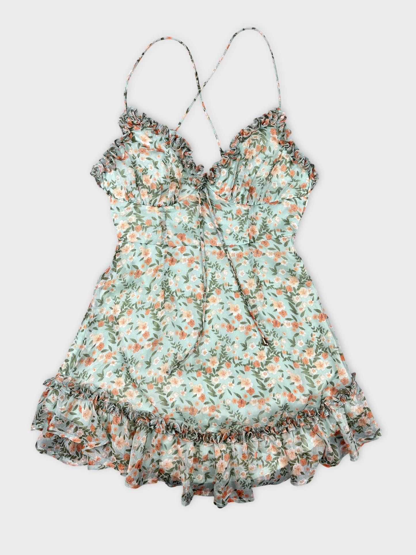 Front view of a floral mint green spaghetti strap top with ruffled trim.
