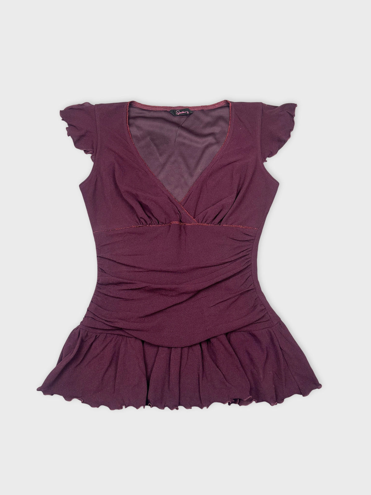 Front view of a burgundy top with ruffled sleeves and flared hem.