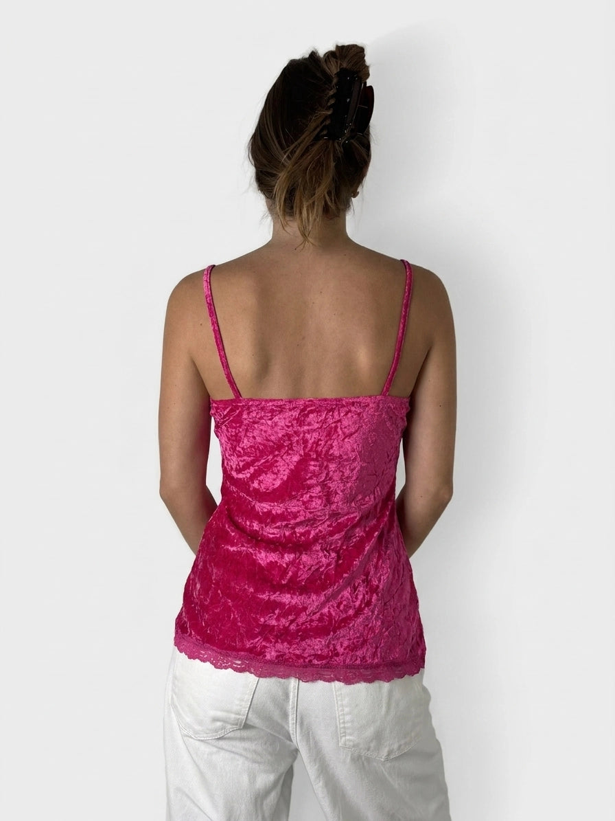 Back view of a pink, lace-trimmed women's top with thin straps.