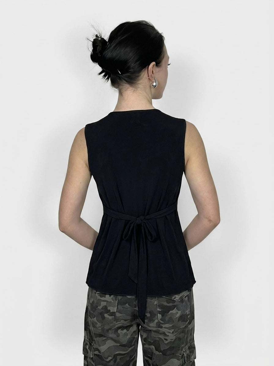 Back view of a sleeveless black top with a bow detail at the waist.