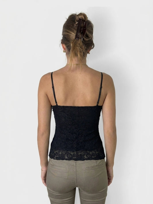 Back view of a black lace camisole top with thin straps.