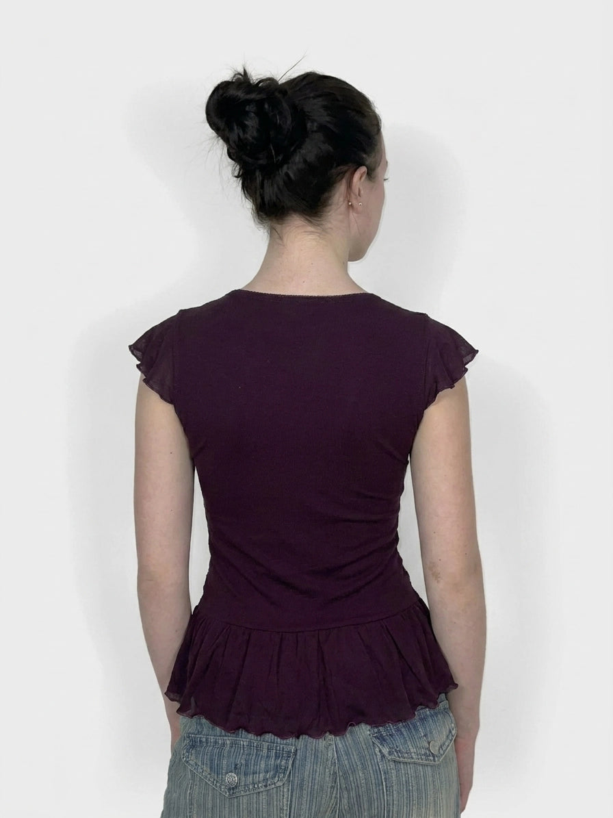 Back view of a purple ruffled top with short sleeves.