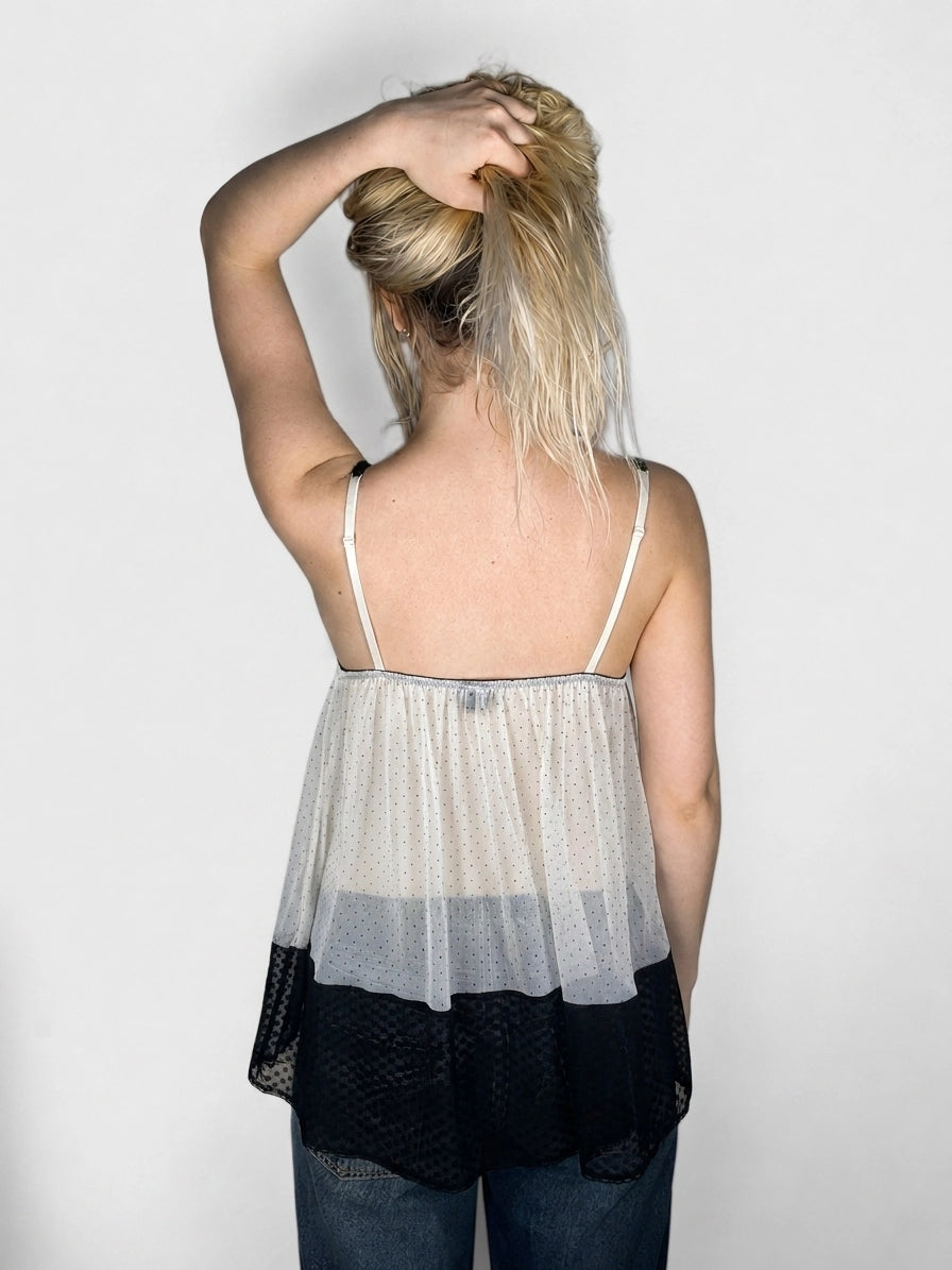 Back view of a women's tank top in cream and black with a polka dot pattern.