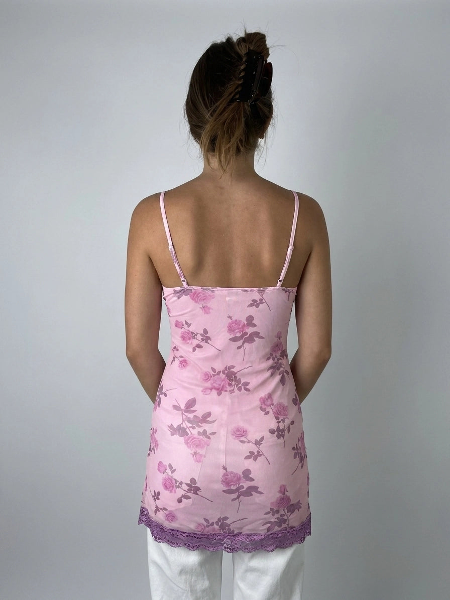 Back view of a pink floral women's top with lace trim.
