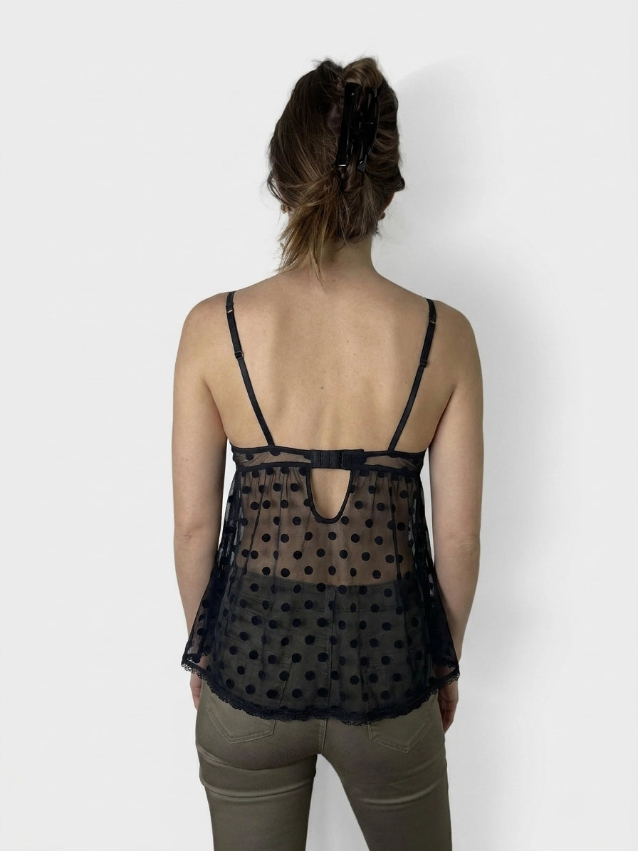 Black polka dot top with lace trim, back view.