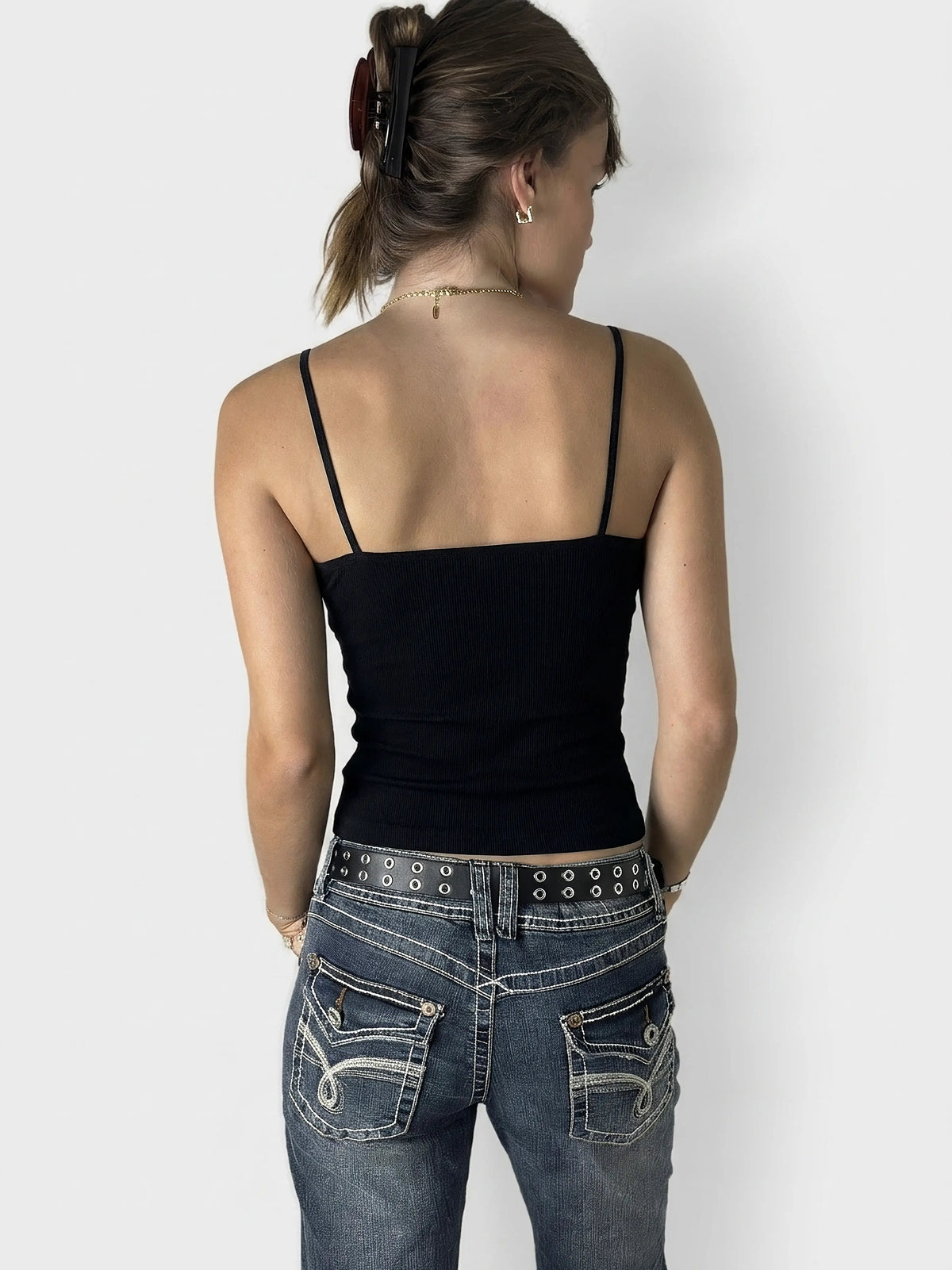 Back view of a black ribbed tank top with thin straps.