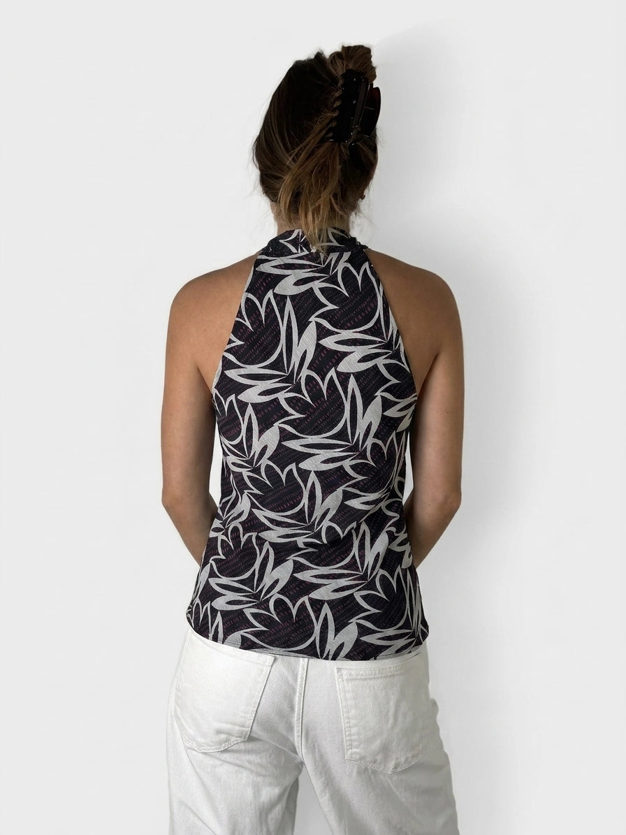 Back view of a black halter top with a white leaf pattern.