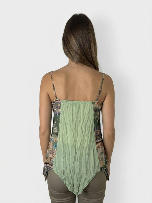 Back view of a green vintage top with a flowing silhouette and patterned detail.